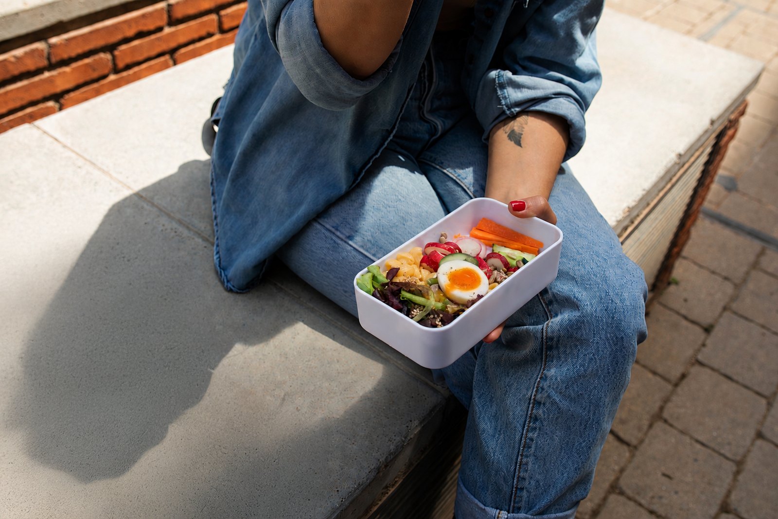 Lunchbox salad with leaves, radish, carrot and a halved jammy egg